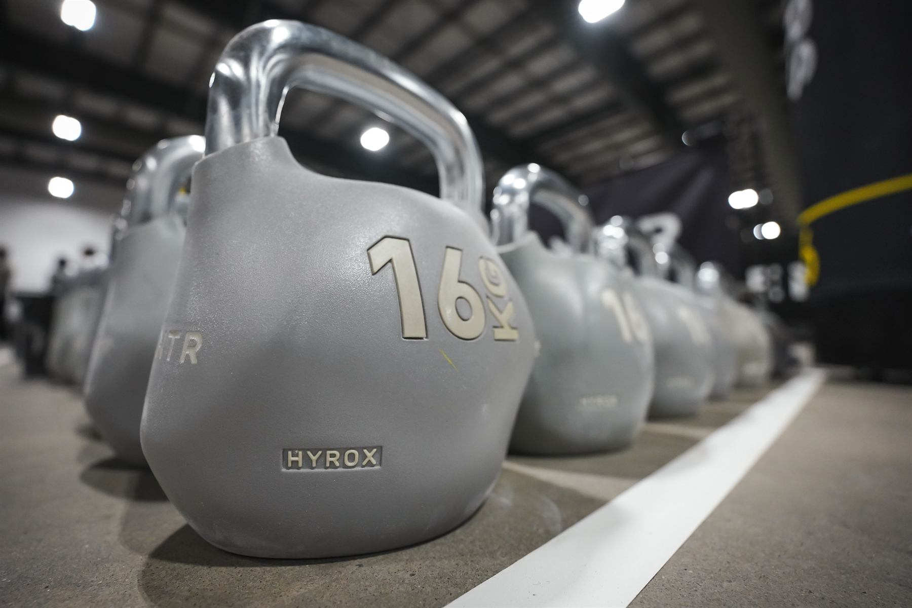 A row of 16 kg kettlebells on the race floor